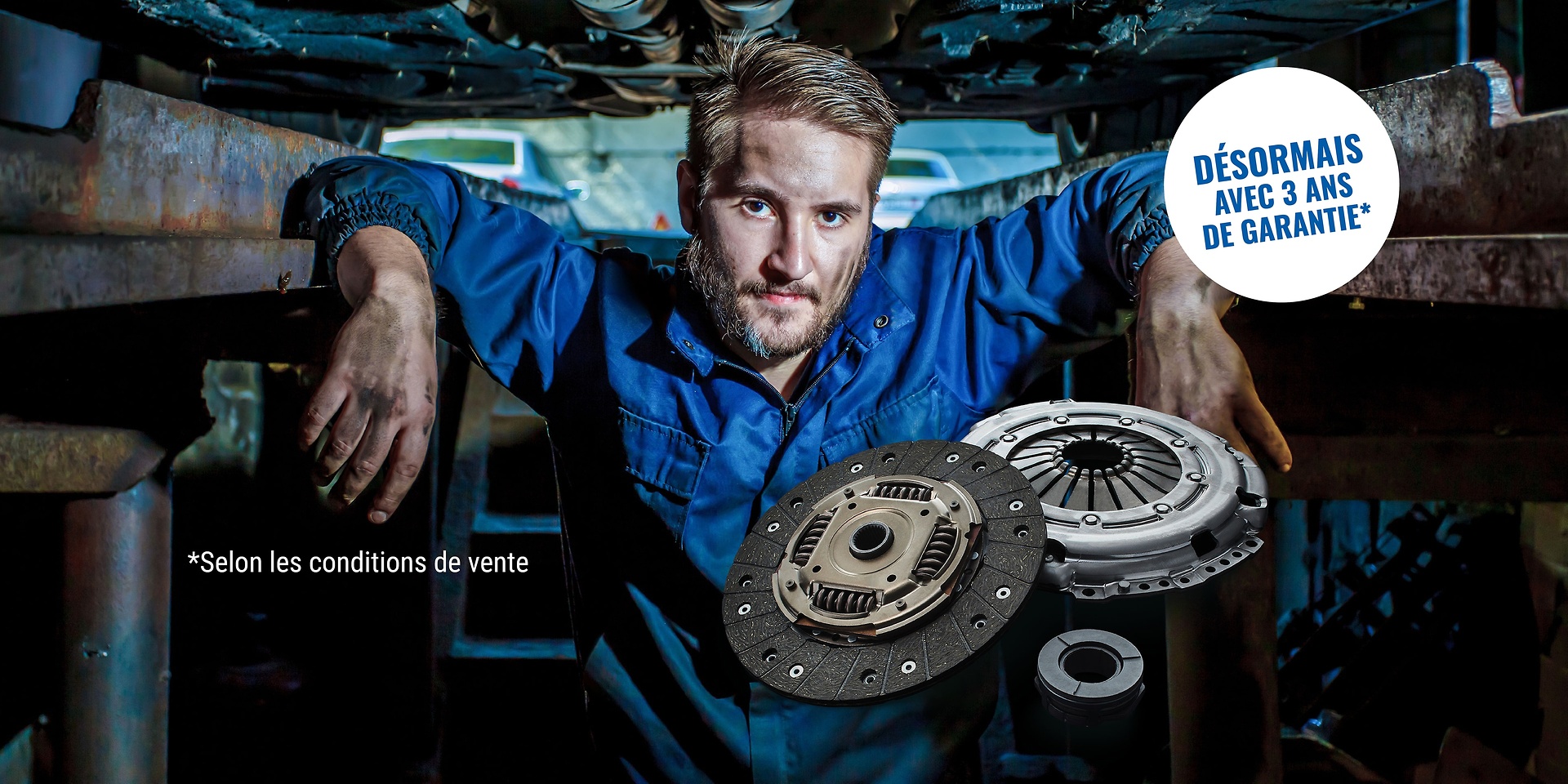 Un mécanicien sous une rampe, avec un embrayage SACHS.