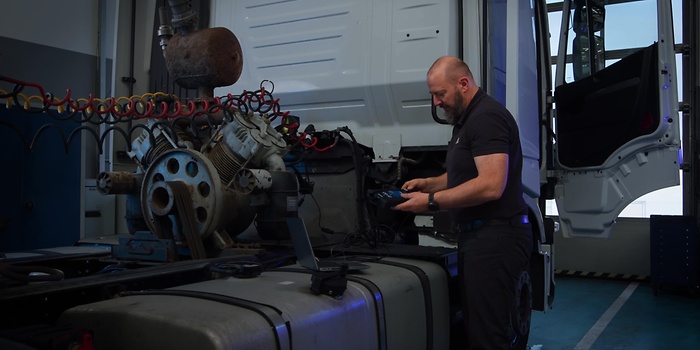 mężczyzna przed ciężarówką z urządzeniem 