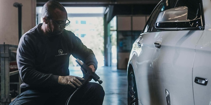 Werkplaatsmedewerker werkt aan auto