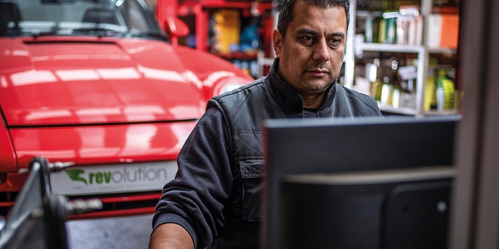 monteur achter computer in werkplaats