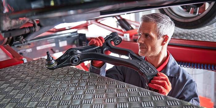 Werkplaatsmedewerker behandelt gebruikte auto-onderdelen