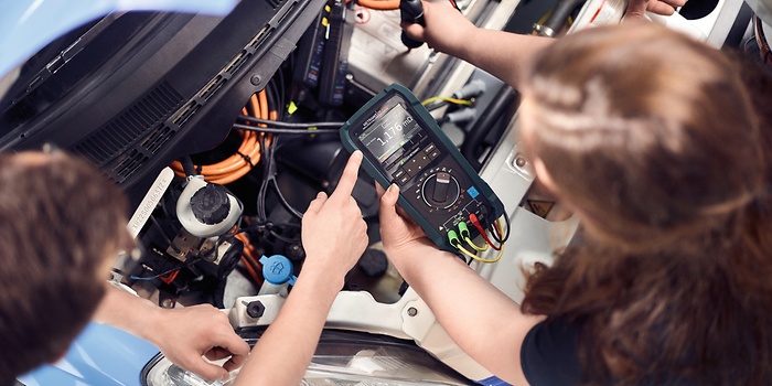 Twee mensen voeren een hoogspanningsmeting uit