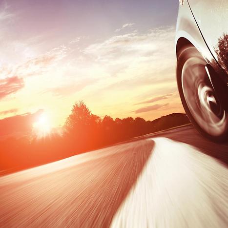 Passenger car on the road at sunrise